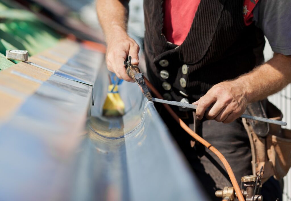man welding gutter