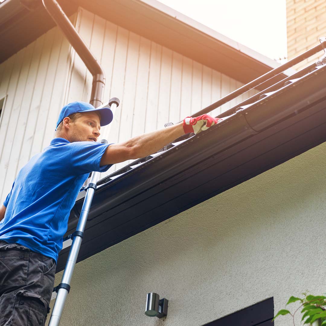 man cleaning gutter