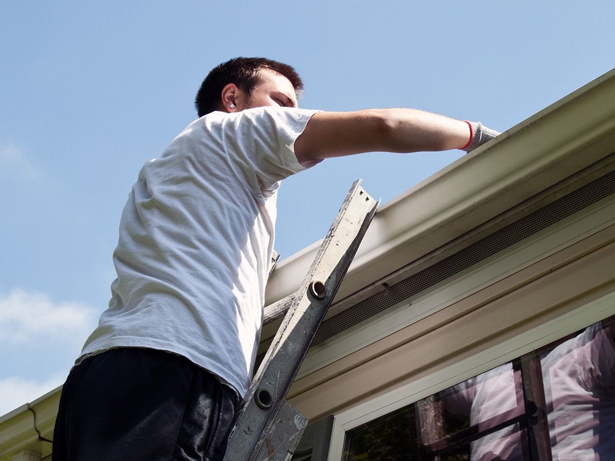 Man cleaning gutters