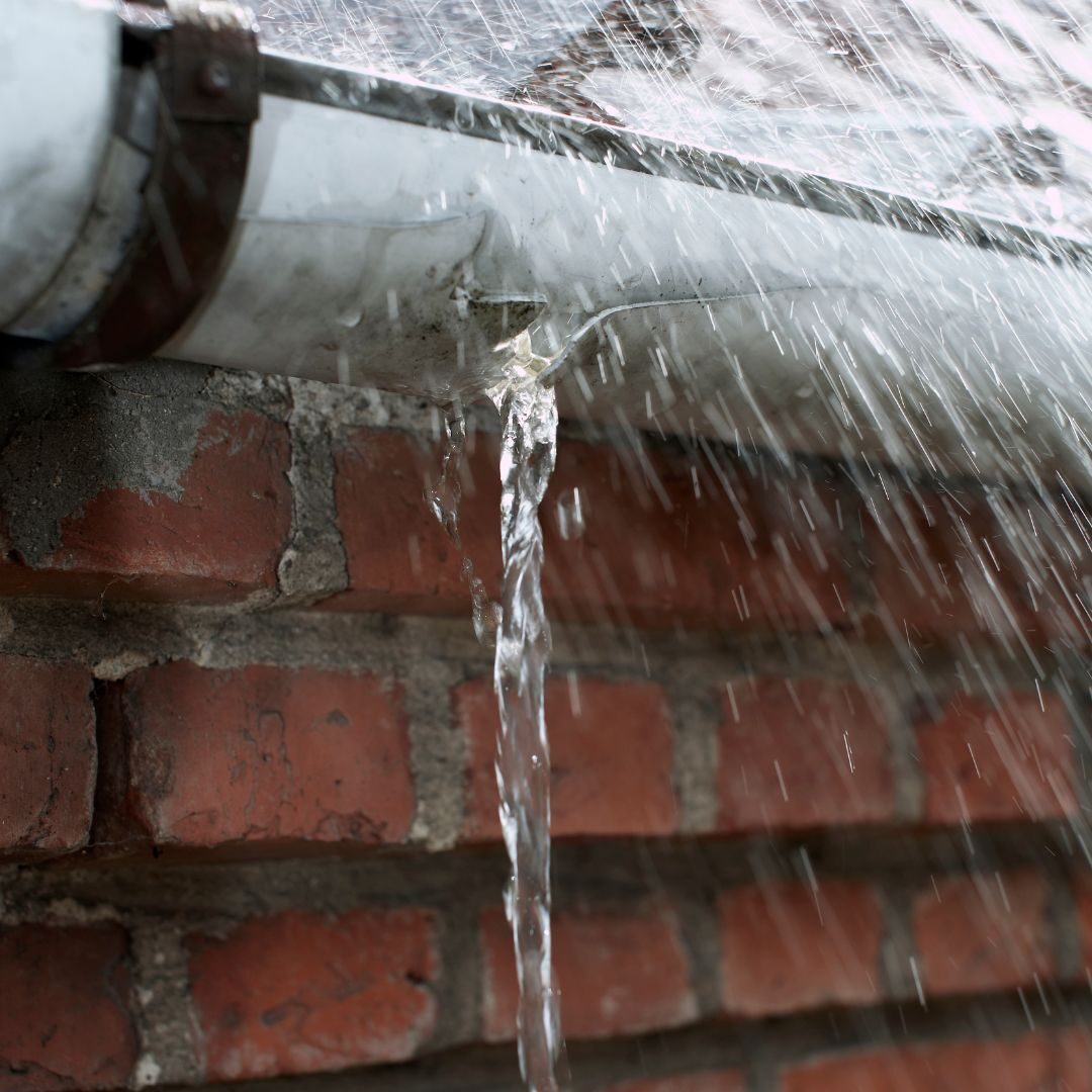 water leaking through a hole in a gutter